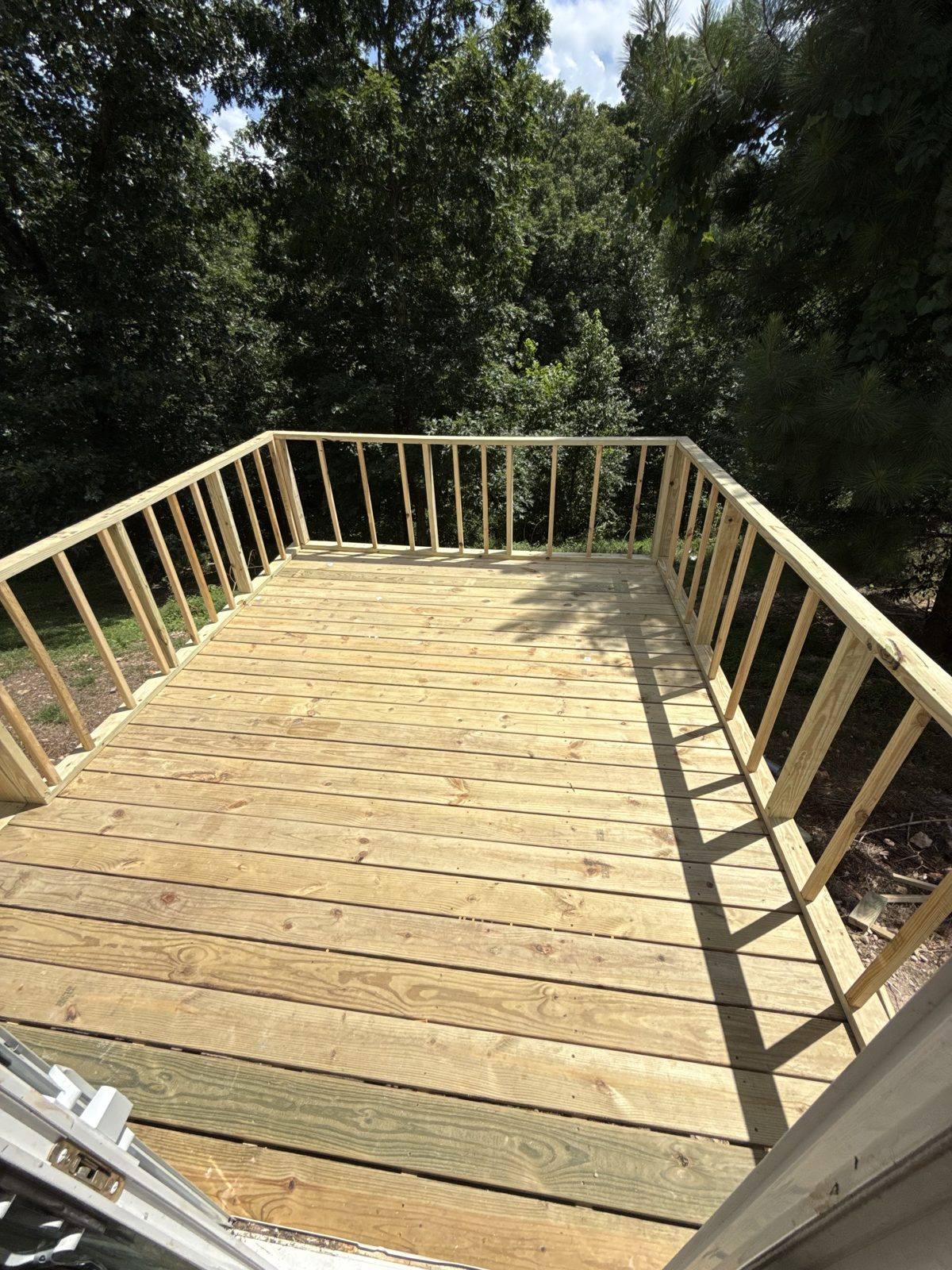 New deck surface and railing overlooking woods
